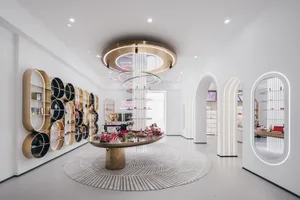 A modern retail store interior with metal shelves, marble counter, and LED lighting.