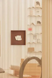 A modern bookshelf adorned with a paper collage.