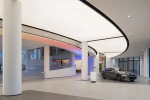 Modern car dealership interior with sleek, minimalist design and use of concrete as a primary material.