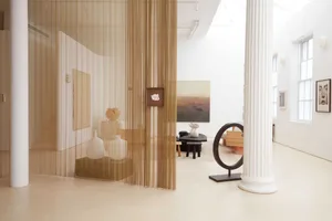 A minimalist interior design featuring wood furniture, fabric curtains, and plaster walls, with a focus on simplicity and fun