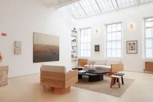A modern living room featuring wood furniture, beige textiles, and a minimalist design.