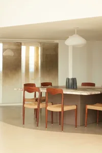 Modern minimalist dining room with a stone dining table and wooden chairs