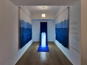 An industrial installation with blue gradient fabric walls creating a minimalist aesthetic.