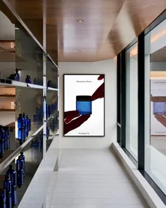 A modern minimalist interior featuring glass shelves displaying various bottles of cosmetic products.