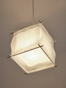 A minimalist textile lighting fixture hanging from the ceiling.