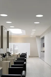 A minimalist waiting room with black seating and marble accents.