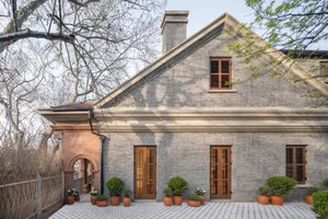 Modern house with brick exterior and wooden doors.