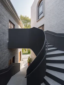 Black concrete spiral staircase with matte finish and smooth, rounded edges.