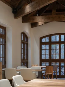 Interior of a restaurant featuring reclaimed wood and white furniture.