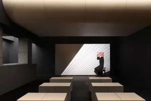 An art installation featuring geometric light projections on a wall.