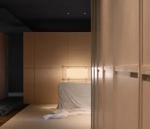 A minimalist interior design with wooden paneling, a light source, and white cloth on the floor.