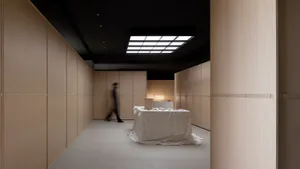 A minimalist office space features light-colored wood walls and furniture, creating a modern and spacious atmosphere.
