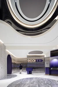 A modern lobby featuring a combination of metal, concrete, and marble materials.
