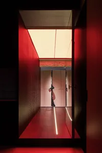 A modern interior space with red lighting and wooden finishes.