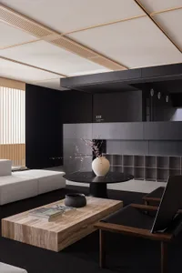 Modern interior design featuring marble coffee table and black chairs with a round black table holding a white vase with cher