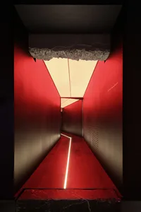 A sleek, minimalist corridor with red metal walls and a glowing white strip of light leading through the hallway.