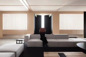 A minimalist living room featuring a white sofa, modern furniture, and wooden accents.