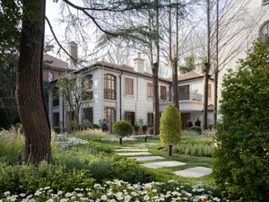 A modern residential design featuring stone materials and landscaping.