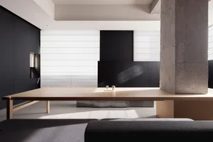 A minimalist residential interior design featuring concrete, wood, and solid surface materials.