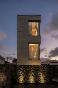 A modern residential building with stucco exterior and large windows.
