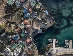 Aerial view of a coastal village with houses, docks, and boats.