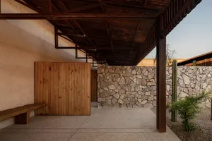 A minimalist architectural interior featuring stone, concrete, and wood materials.