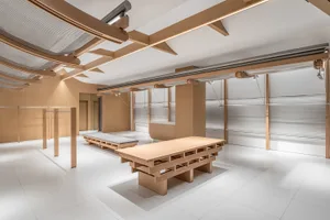 Minimalist commercial interior with wooden benches and cement floor