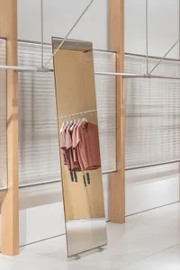 現代吊掛衣架在極簡零售店內展示金屬粉色襯衫。