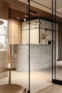 A modern office interior featuring a stone reception counter with minimalist decor and ambient lighting.