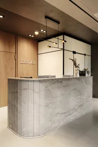 Modern office lobby featuring a sleek, gray marble reception desk with minimalist design