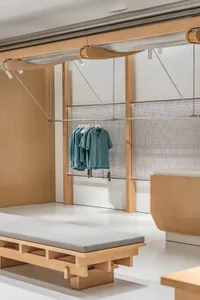 A modern retail store with a hanging clothing rack made of wood.
