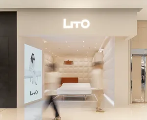 Modern retail storefront with large image display and cushioned seating area.