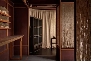 Minimalist living space featuring wooden furniture, fabric curtains, and traditional design elements.