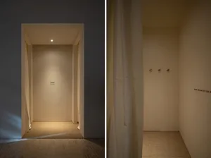 Minimalist retail fitting room with neutral colors and simple design.