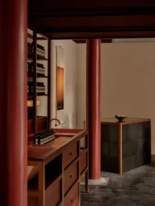 A minimalist spa interior featuring wooden cabinets, concrete walls, and metallic accents.