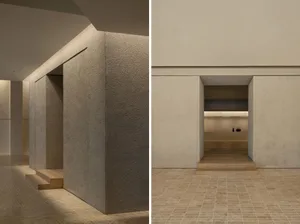 Minimalist concrete interior design featuring a modern lobby with textured walls and tiled flooring.