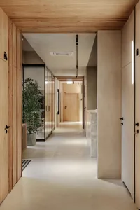 Modern interior design featuring a corridor with wooden walls and concrete flooring.