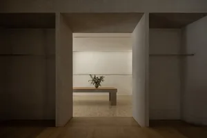 極簡衣帽間內部，設有混凝土長椅與花卉擺飾。