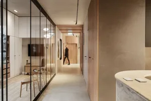 A sleek, minimalist residential interior with concrete flooring and furniture.