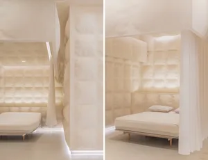 A minimalist bedroom with soft textiles, featuring a bed and a curtain.
