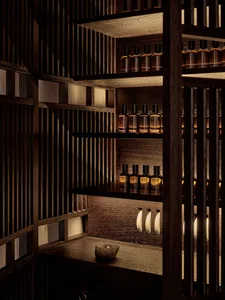 A wooden shelf with multiple bottles arranged neatly.