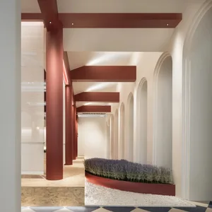 Modern interior design featuring a corridor with concrete flooring, concrete walls, and concrete columns, illuminated by warm