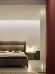 A minimalist bedroom featuring a mahogany bed with a brown leather headboard.