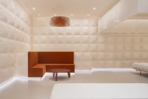 A minimalist hotel suite with white and neutral fabrics in a contemporary design.