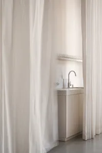 A minimalist spa interior features a glass curtain wall and clean, open spaces.