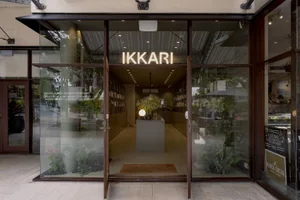 Ikari restaurant storefront with glass walls and a neon sign reading 'IKKARI'.