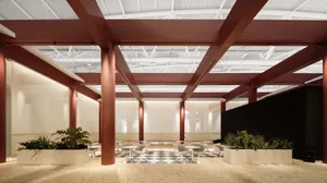 An industrial-style office space with metal columns supporting a glass roof.