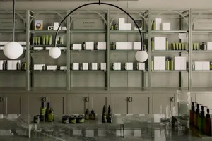 Modern retail storefront with greenery, matte finishes, and black metal accents.