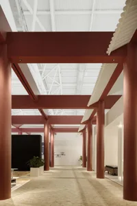 An interior view of a modern office space featuring metallic transparent roof and columns.