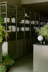 Modern spa retail interior with glass shelves and flowers decor.